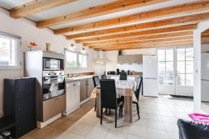 a kitchen with wooden ceilings and a table with chairs at Maison Boyardville Piscine in Saint-Georges-dʼOléron