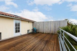 a wooden deck with a fence in front of a house at Maison Boyardville Piscine in Saint-Georges-dʼOléron