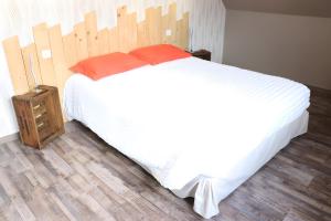 a bedroom with a large white bed with a wooden headboard at Gîte La Maison De Caroline, Spa in Sigolsheim