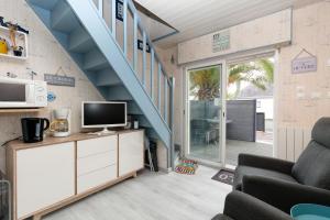 a living room with a staircase and a television at Le pré Nantais proche plage in Le Croisic