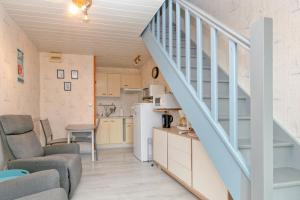 a kitchen and a living room with a staircase at Le pré Nantais proche plage in Le Croisic +15 photos