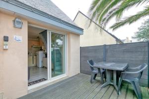 a patio with a table and chairs on a deck at Le pré Nantais proche plage in Le Croisic