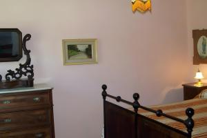 a bedroom with a bed and a tv and a dresser at Villa con parco e piscina-Camaiore in Nocchi