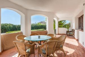 a patio with a table and chairs and windows at Apartamentos Villa Martinez in Salobreña