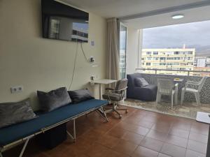 a living room with a couch and a table and a window at Los Molinos 735 in Maspalomas