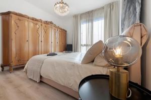 a bedroom with a large bed with a wooden headboard at Lake Como Style Home in Lecco