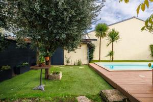 a backyard with a tree and a swimming pool at Suite dans une échoppe in Bègles