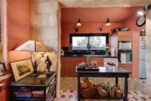 a kitchen with orange walls and a table with a lamp at Suite dans une échoppe in Bègles