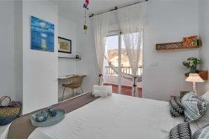a bedroom with a large white bed and a table at Casa Sueña in Calahonda