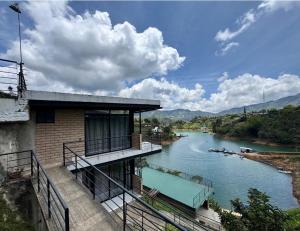 a building with a balcony next to a river at Springfield Ecoloft- Guatapé in Guatapé