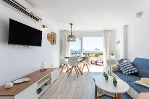 a living room with a blue couch and a table at Seafront Beach house Rocas del Mar in Mijas