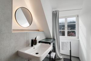 a white bathroom with a sink and a mirror at Altes Forstamt in Gernsbach +19 photos