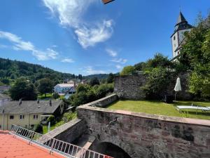 an old stone bridge with a castle in the background at Altes Forstamt in Gernsbach