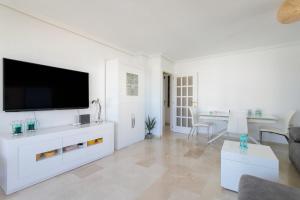 a living room with a flat screen tv on a white wall at Torre Mar Muchavista in El Campello