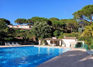 a swimming pool with a villa in the background at Un Petit Paradis à Gigaro in La Croix-Valmer