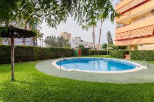 a small swimming pool in a yard next to a building at Torre Mar Muchavista in El Campello