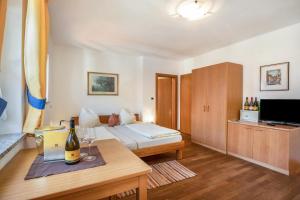 a hotel room with a bed and a table with wine glasses at Weingut Lieselehof Apt Vitis in Caldaro
