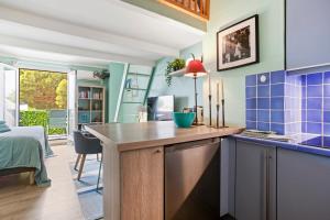 a kitchen with blue tiles and a counter with a table at Un Petit Paradis à Gigaro in La Croix-Valmer
