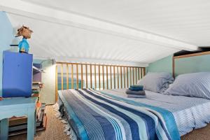 a bedroom with a bed with a blue and white striped blanket at Un Petit Paradis à Gigaro in La Croix-Valmer +33 photos