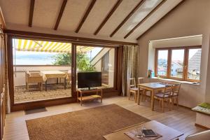 a living room with a television and a dining room with a table at Bodenseeblick in Konstanz