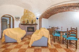 a living room with a table and chairs and a fireplace at La Higuera in Benalúa de Guadix
