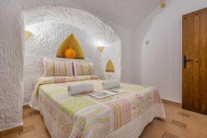 a bedroom with a bed with a laptop on it at La Higuera in Benalúa de Guadix +23 photos