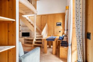 a wooden house with a staircase and a living room at Apartment Vajolet in Campitello di Fassa