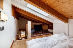 a bedroom with a bed in a room with wooden ceilings at Apartment Vajolet in Campitello di Fassa
