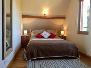 a bedroom with a large bed with red pillows at Le Chêne Doux in Glandon