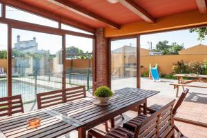 an outdoor patio with a wooden table and chairs at Casa Chiqui - solo familias in Conil de la Frontera