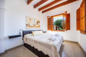 a bedroom with a large bed and a window at Son Calletes in Artá +24 photos