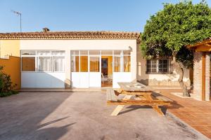 a picnic table in front of a house at Casa Chiqui - solo familias in Conil de la Frontera