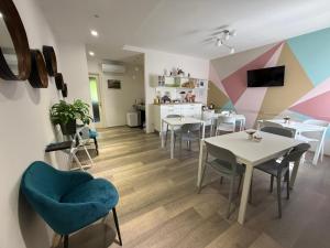 a dining room with tables and chairs and a kitchen at La Coccinella in Iesi
