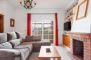 a living room with a couch and a fireplace at Casa Chiqui - solo familias in Conil de la Frontera