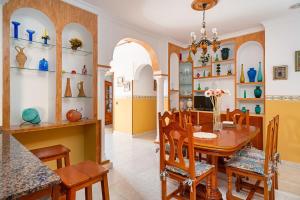 a kitchen and dining room with a table and chairs at Casa Chiqui - solo familias in Conil de la Frontera