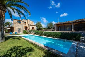 a villa with a swimming pool in front of a house at Son Calletes in Artá