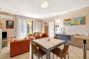 a kitchen and a living room with a table and chairs at La Casa Di Freddy - Loano in Loano