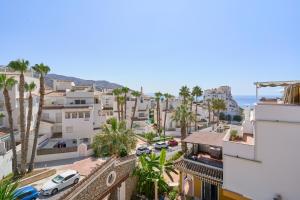 a view of a city with palm trees and the ocean at Lily in Almuñécar