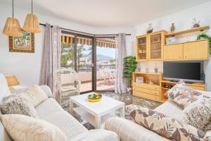 a living room with a couch and a tv at Lily in Almuñécar