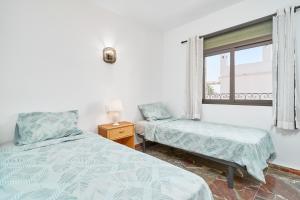 a bedroom with two beds and a window at Lily in Almuñécar