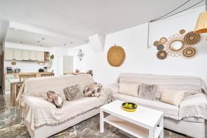 a living room with two white couches and a kitchen at Lily in Almuñécar