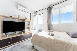 a bedroom with a flat screen tv and a bed at Studio Vista Bonita in Sitio de Calahonda