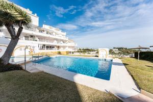 a swimming pool in front of a building at Studio Vista Bonita in Sitio de Calahonda