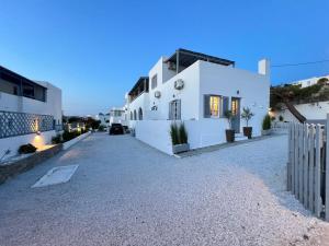 a white house with a fence in front of it at aeolian blu 9 in Parikia