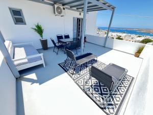 a patio with chairs and a table on a balcony at aeolian blu 9 in Parikia