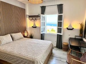 a bedroom with a bed and a desk and a window at aeolian blu 9 in Parikia +37 photos