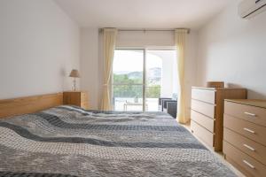 a bedroom with a bed and a large window at Casa Curumbico in Almuñécar