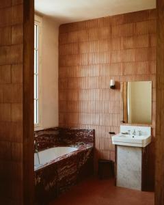 a bathroom with a tub and a sink and a mirror at CHB - Château de la Haute Borde in Rilly-sur-Loire
