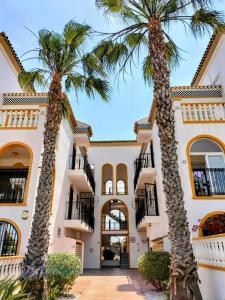 two palm trees in front of a building at Good Atmosphere in Orihuela