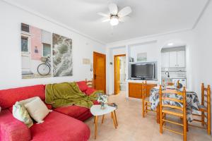 a living room with a red couch and a table at Good Atmosphere in Orihuela